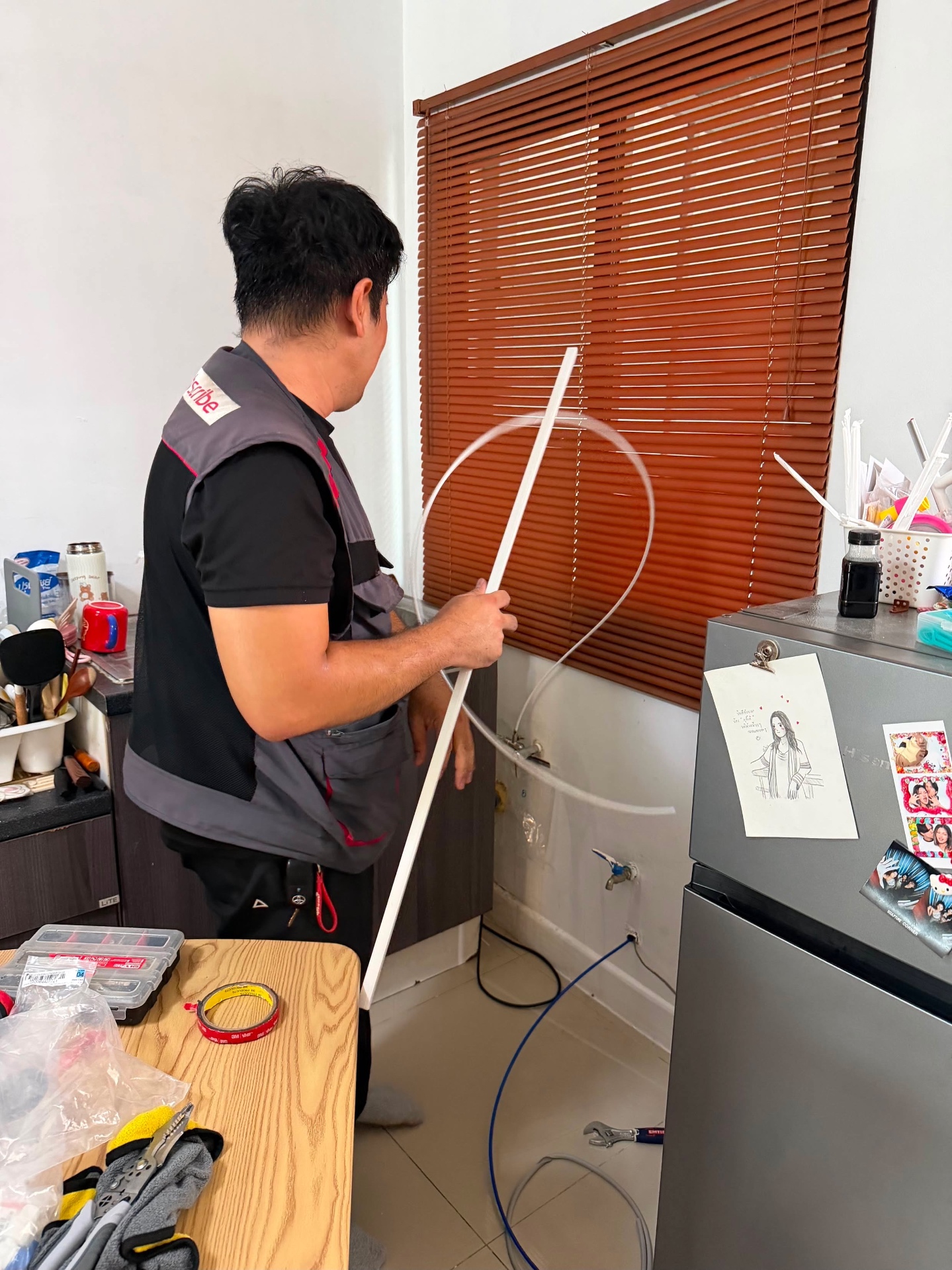 ช่างเดินท่อน้ำเข้าเครื่องกรองน้ำ LG พร้อมรางครอบให้เรียบร้อย